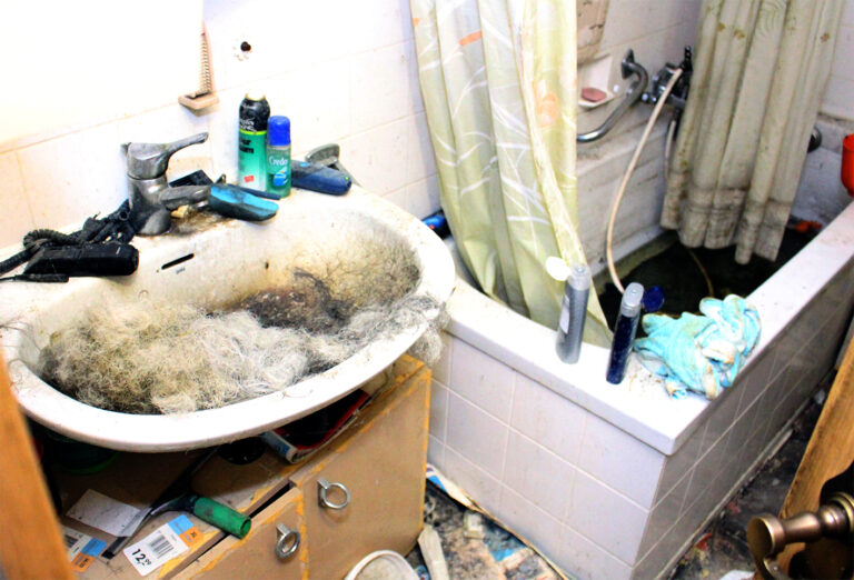 Messie Bad. Viel Gerümpel und das Waschbecken ist voller Haare.